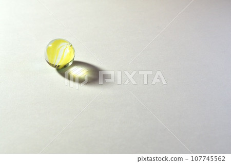 Yellow marbles and shadow white background 107745562