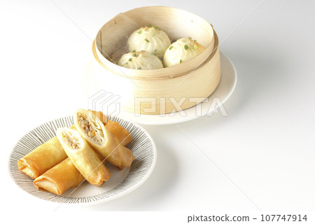 Fried spring rolls and piping hot xiao long bao in a steamer basket Fried spring rolls and piping hot xiao long bao in a steamer basket 107747914
