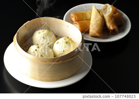 蒸籠裡滾燙的小籠包和炸春捲 107748023