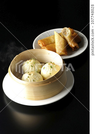 蒸籠裡滾燙的小籠包和炸春捲 107748028