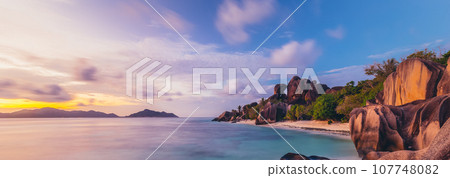 Beautifully shaped granite boulders and a dramatic sunset at picture perfect tropical Anse Source d'Argent beach, La Digue island, Seychelles. Beautifully shaped granite boulders and a dramatic sunset at picture perfect tropical Anse Source d'Argent beach, La Digue island, Seychelles. 107748082
