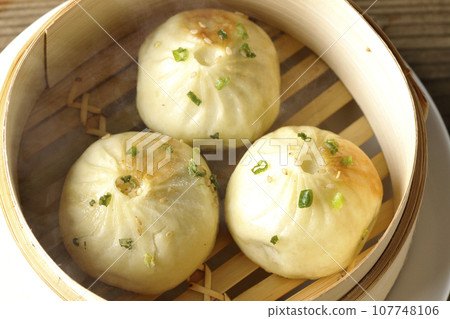 俯視蒸籠裡蒸著的熱氣騰騰的小籠包 俯視蒸籠裡蒸著的熱氣騰騰的小籠包 107748106