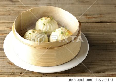 Hot steamed dumplings in a steamer 107748121