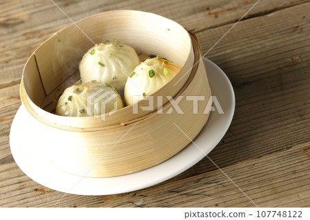 Hot steamed dumplings in a steamer 107748122