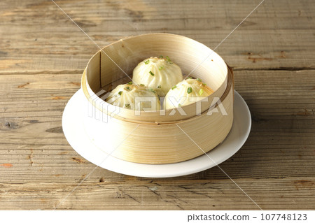 Hot steamed dumplings in a steamer 107748123