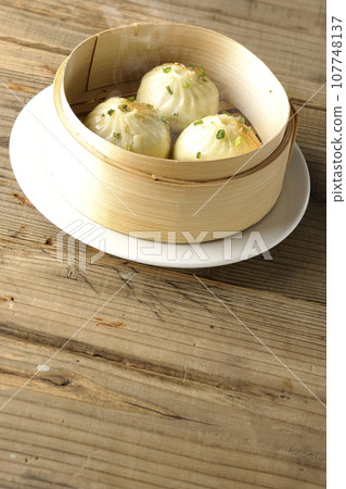 Hot steamed dumplings in a steamer 107748137