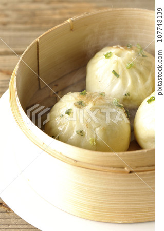 Hot steamed dumplings in a steamer 107748139