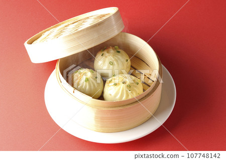Hot steamed dumplings in a steamer 107748142