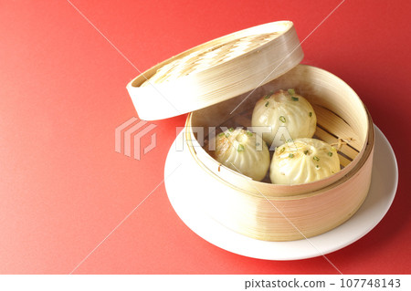 Hot steamed dumplings in a steamer 107748143