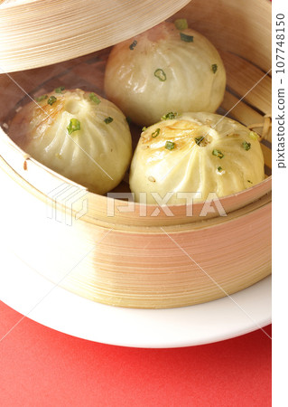 Hot steamed dumplings in a steamer Hot steamed dumplings in a steamer 107748150