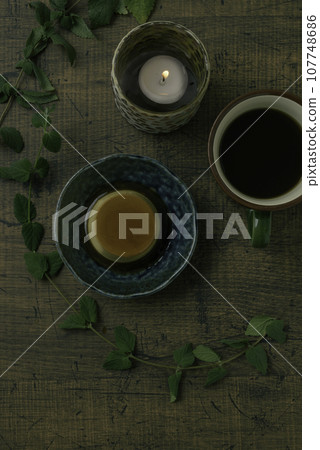 桌上列印咖啡、蠟燭和室內植物，垂直位置 107748686