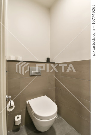 a toilet in the corner of a bathroom with tile on the floor and walls, it's all white a toilet in the corner of a bathroom with tile on the floor and walls, it's all white 107749263