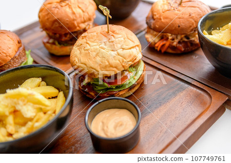 Street food, fast food. Burgers with beef, cheese and onions on the wooden table 107749761