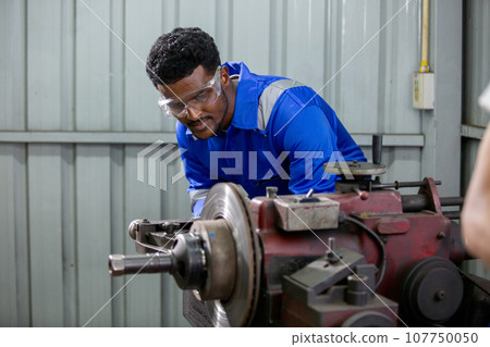 Technician worker man African American wearing uniform safety working machine lathe metal brake. 107750050