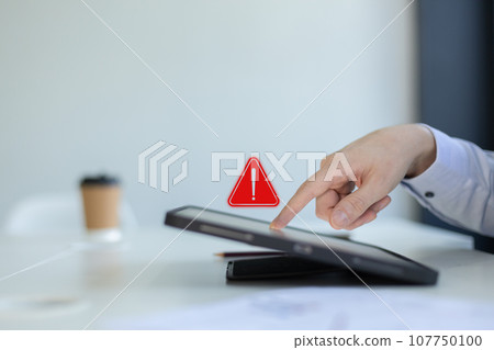 businessman using tablet with notification error. warning sign over on mobile phone. 107750100