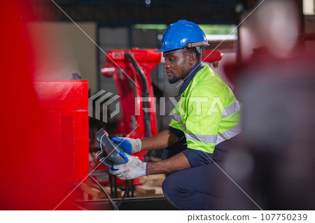 Male american african technician holding remote control automation robotics at industrial Male american african technician holding remote control automation robotics at industrial 107750239