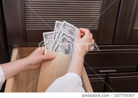 [一位家庭主婦將一張一萬日元的鈔票藏在抽屜裡的信封裡] 107750367