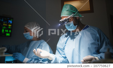 Dentist extracts tooth with surgical instruments Dentist extracts tooth with surgical instruments 107750627