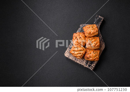 Delicious crispy mini puffs with sausage or meat with salt, thyme and sesame 107751230