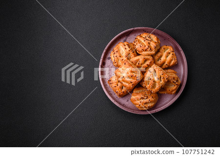 Delicious crispy mini puffs with sausage or meat with salt, thyme and sesame 107751242