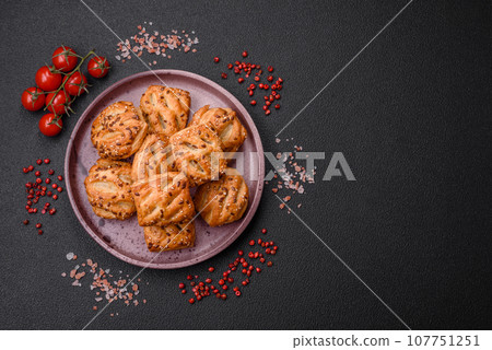 Delicious crispy mini puffs with sausage or meat with salt, thyme and sesame 107751251