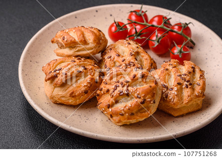 Delicious crispy mini puffs with sausage or meat with salt, thyme and sesame Delicious crispy mini puffs with sausage or meat with salt, thyme and sesame 107751268