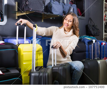 Female customer choosing travel suitcase 107751400