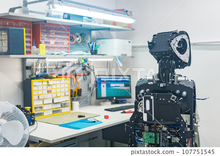 humanoid robot in the process of assembly and adjustment in the workshop 107751545