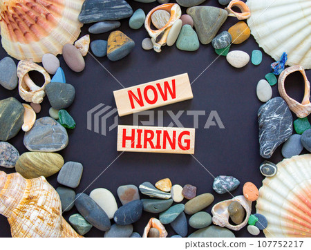 Now hiring symbol. Concept words Now hiring on beautiful wooden block. Beautiful black table black background. Sea stone sea shell. Business marketing, motivational now hiring concept. Copy space. 107752217