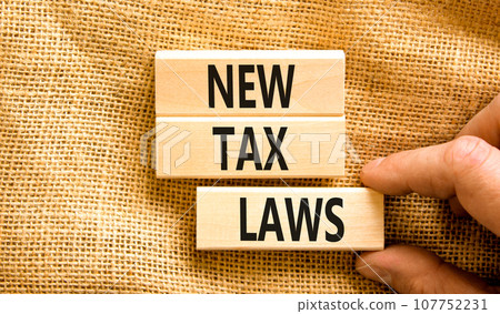 New tax laws symbol. Concept words New tax laws on wooden blocks on a beautiful canvas table canvas background. Businessman hand. Business new tax laws concept. Copy space. 107752231