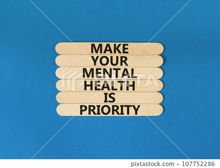 Mental health psychological symbol. Concept words Make your mental health a priority on wooden blocks on a beautiful blue table blue background. Psychological mental health concept. 107752286