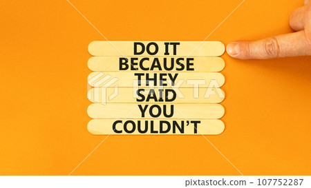 You can do it symbol. Concept words Do it because they said you could not on wooden stick. Beautiful orange background. Businessman hand. Business, motivational you can do it concept. Copy space. 107752287