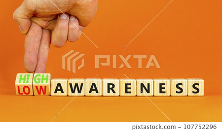 High or low awareness symbol. Concept words High awareness Low awareness on wooden blocks. Beautiful orange background. Businessman hand. Business High or low awareness concept. Copy space. High or low awareness symbol. Concept words High awareness Low awareness on wooden blocks. Beautiful orange background. Businessman hand. Business High or low awareness concept. Copy space. 107752296