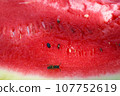 Close-up of the flesh of a ripe red, pink watermelon with a bee sitting on it 107752619