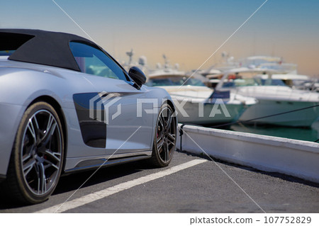 Luxury sports car on the background of yachts. 107752829