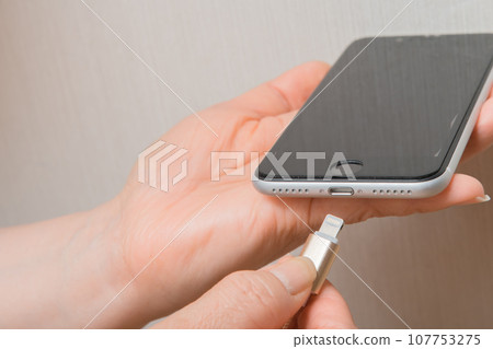[Housewife charging her smartphone] 107753275