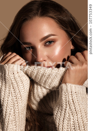 Beautiful young girl with gentle make-up in warm sweater and long straight hair. Beauty face. Beautiful young girl with gentle make-up in warm sweater and long straight hair. Beauty face. 107753349