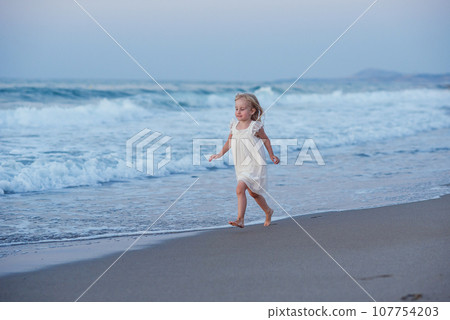 Happy little girl running and jumping at beach Happy little girl running and jumping at beach 107754203