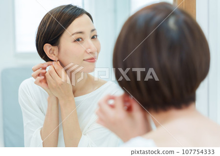 在化妝間戴耳環的女人 在化妝間戴耳環的女人 107754333