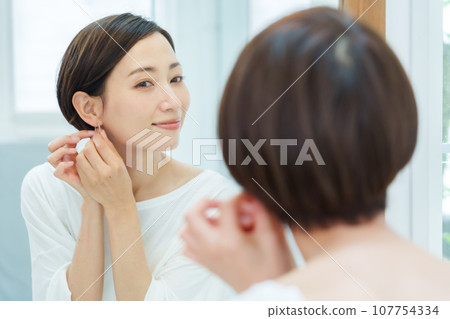 在化妝間戴耳環的女人 在化妝間戴耳環的女人 107754334