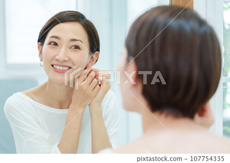 在化妝間戴耳環的女人 在化妝間戴耳環的女人 107754335