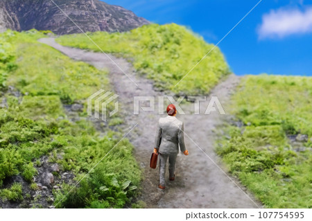 A businessman standing at a crossroads A businessman standing at a crossroads 107754595