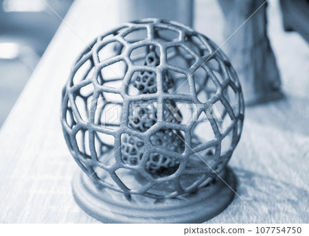 Abstract model Christmas tree in mesh ball printed on 3D printer from polyamide powder close-up. Technology Multi Jet Fusion, MJF. Three-dimensional model created on 3D printer from powder plastic Abstract model Christmas tree in mesh ball printed on 3D printer from polyamide powder close-up. Technology Multi Jet Fusion, MJF. Three-dimensional model created on 3D printer from powder plastic 107754750