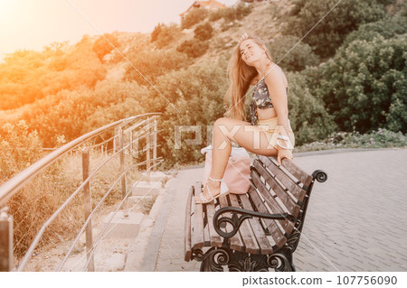 Woman travel sea. Happy tourist enjoy taking picture outdoors for memories. Woman traveler looks at the edge of the cliff on the sea bay of mountains, sharing travel adventure journey Woman travel sea. Happy tourist enjoy taking picture outdoors for memories. Woman traveler looks at the edge of the cliff on the sea bay of mountains, sharing travel adventure journey 107756090