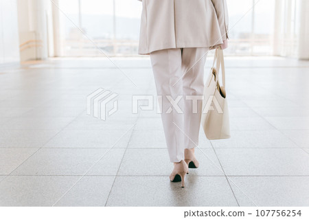 Back view of a woman/business woman walking in pumps/high heels (commuting, going to work, progressing, progressing, challenging) 107756254
