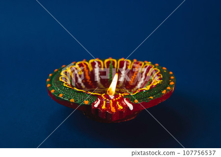 Colorful clay diya lamps shine bright, happiness and prosperity. Perfect for Diwali Holi and religion-themed invitations. Shiny, glowing lamps festive ambiance. Diwali and Holi celebration. Colorful clay diya lamps shine bright, happiness and prosperity. Perfect for Diwali Holi and religion-themed invitations. Shiny, glowing lamps festive ambiance. Diwali and Holi celebration. 107756537