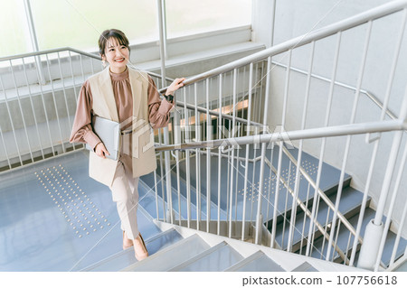 一名女性/女商人在辦公室爬樓梯（早上、上班、上班、節食、日常活動） 107756618
