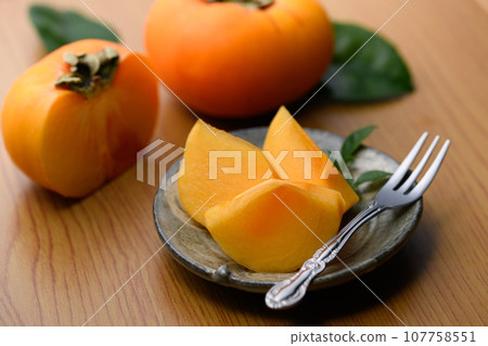 A very sweet autumn taste Persimmon fruit on a plate (table back) Persimmon fruit Persimmon fruit 107758551