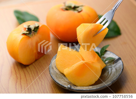 A very sweet taste of autumn Picking up persimmons on a plate with a fork Fruit (table back) Persimmon fruit Oysters A very sweet taste of autumn Picking up persimmons on a plate with a fork Fruit (table back) Persimmon fruit Oysters 107758556