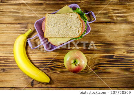 Premium Photo  Lunch box filled with sandwich near two thermos, fresh  apples and oranges, bananas in front of white modern kitchen table